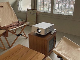 우드 인테리어의 아늑한 방 안 탁자 위에 놓인 LG 시네빔